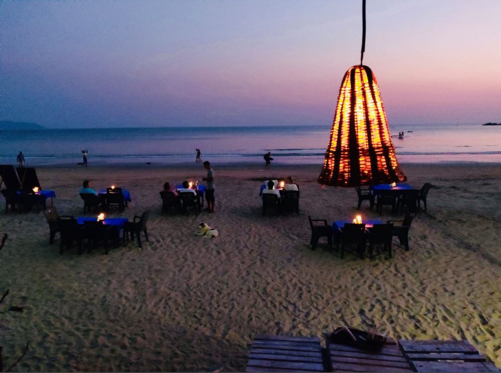 Rows of candlelit tables at Palolem beach at night