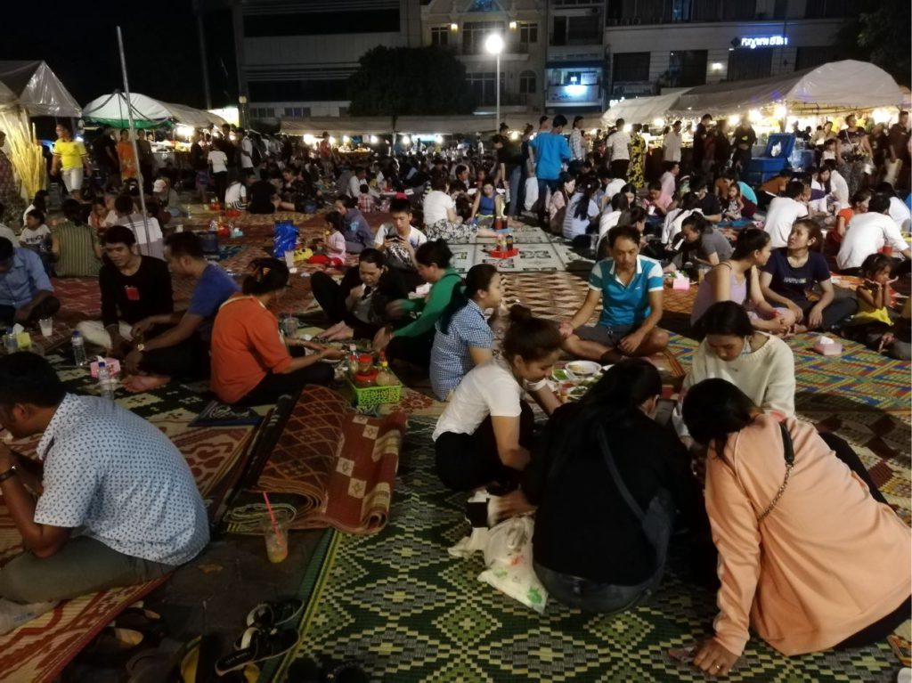 People eating on mats at the night market in Phnom Penh