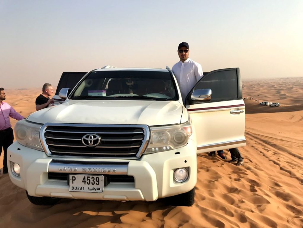 A vehicle with tour guide carrying tourists for desert safari