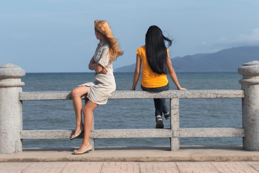 Two female friends looking at the sea