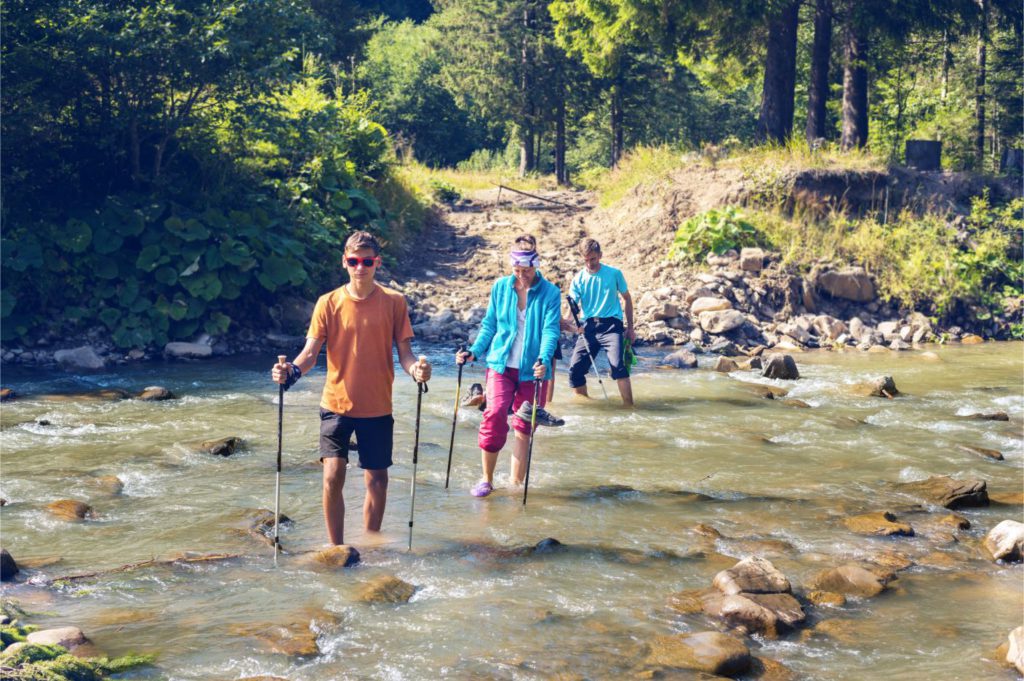 A family crossing a river in the outdoors