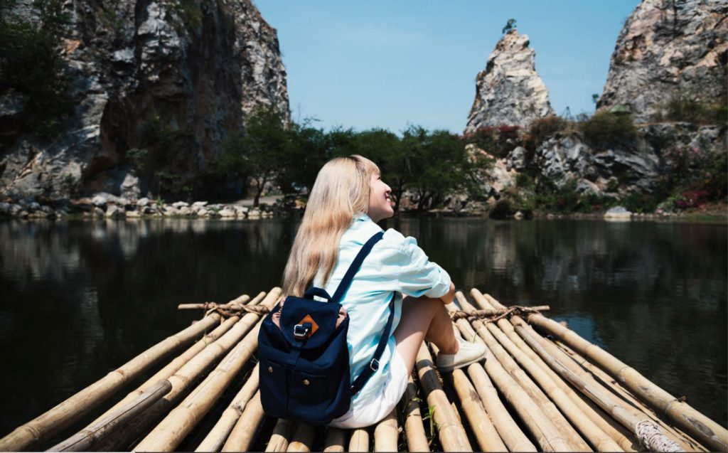 A girl on a bamboo raft on a lake on a solo trip