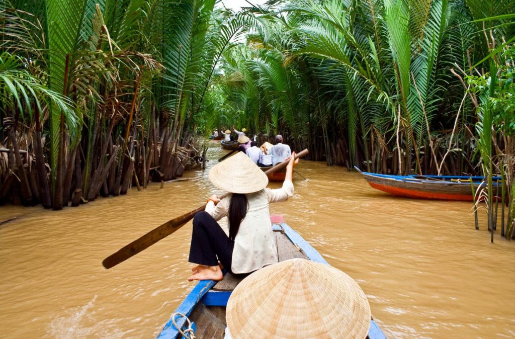 Riding on traditional wooden boats in Mekong Delta