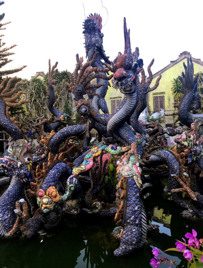 Statue of intricate dragons in a courtyard at one of the old buildings in Hoi An