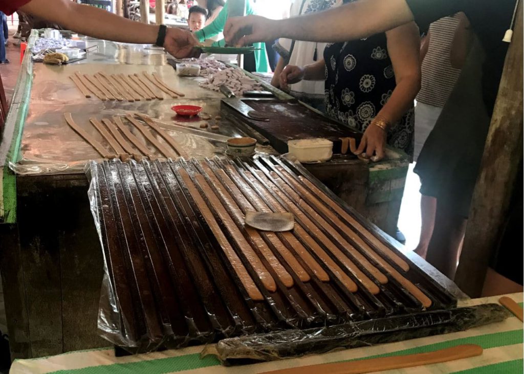 Candy making process with farm equipment at the coconut farm in Mekong delta, Vietnam