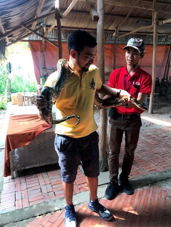 WIth the owner's pet anaconda on coconut farm in Mekong delta, Vietnam