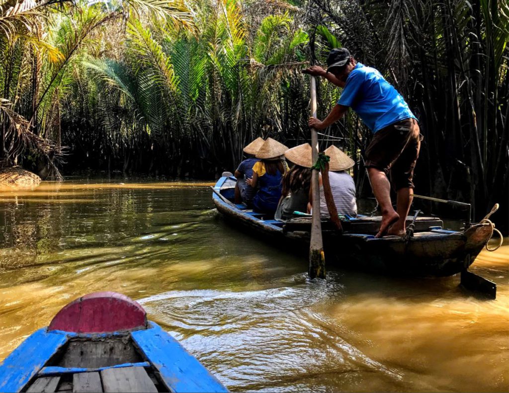 Riding a traditional Vietnamese wooden boar on the Mekong Delta