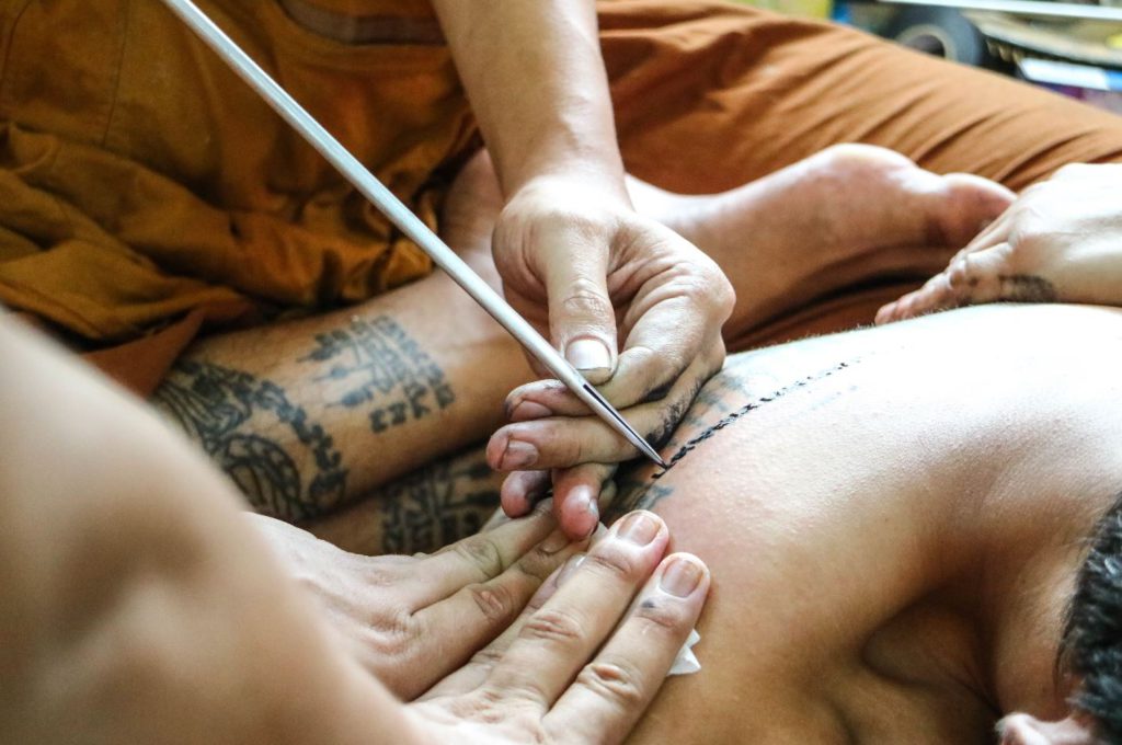 A monk making a Sak Yant tattoo