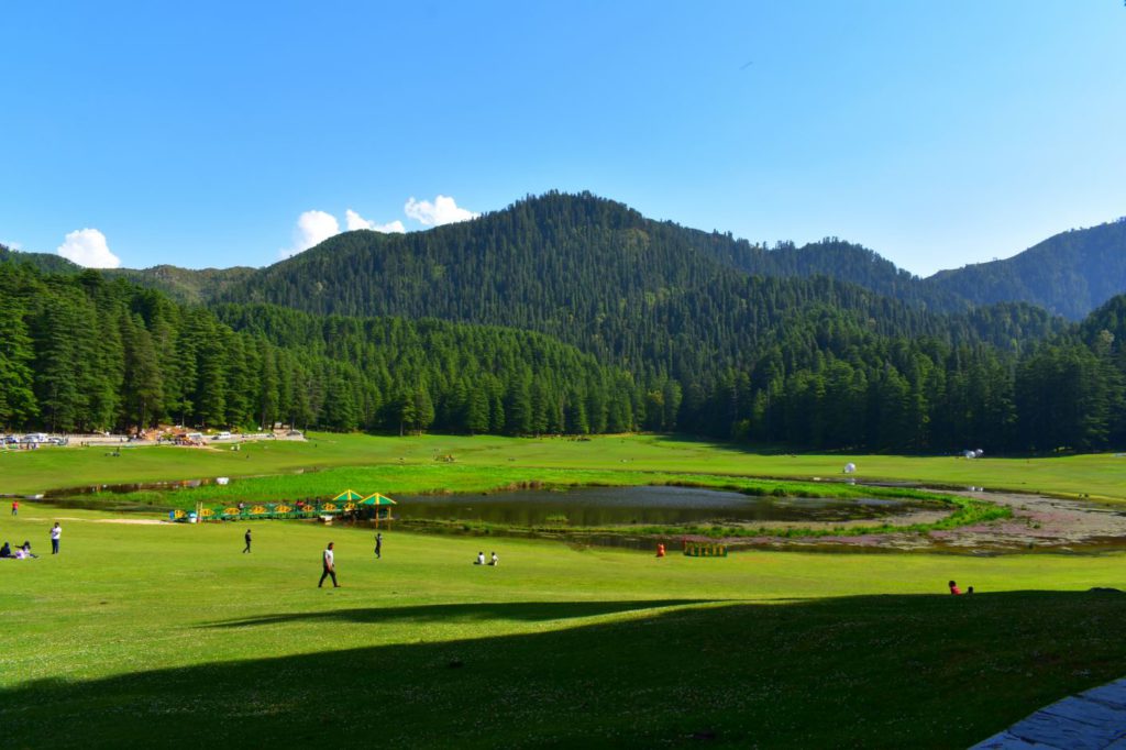 People relaxing on a day out in Khajjiar Meadow