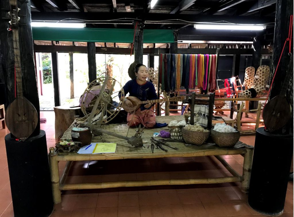 A lady playing local songs inside the Noble House, Nan, Thailand