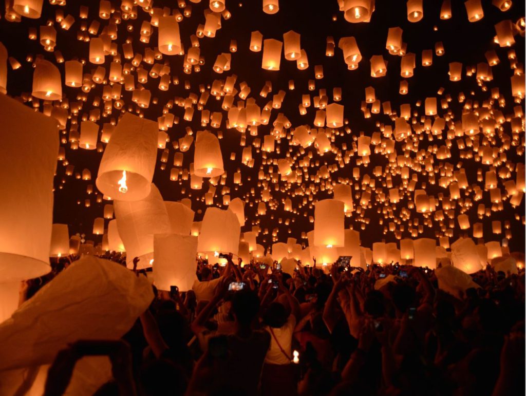 People releasing floating lanterns in sky Chiang Mai