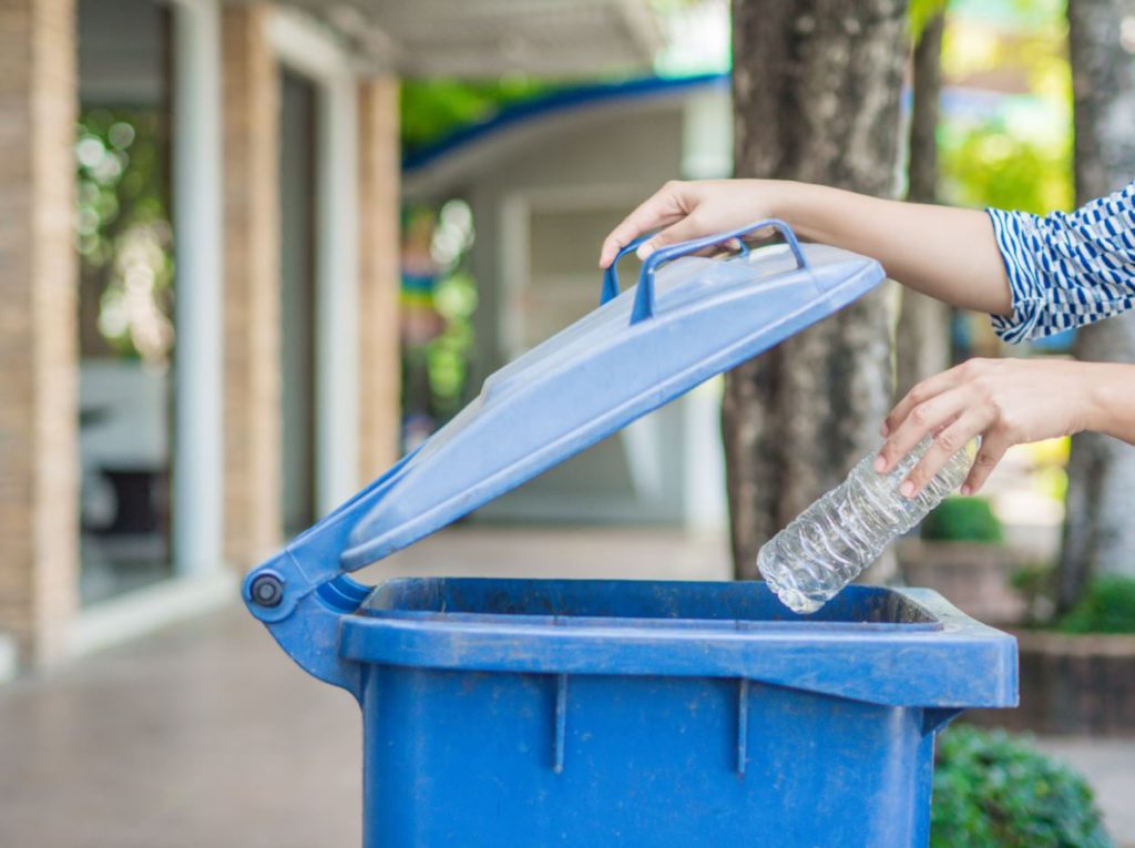 Throwing plastic bottle in to a garbage bin