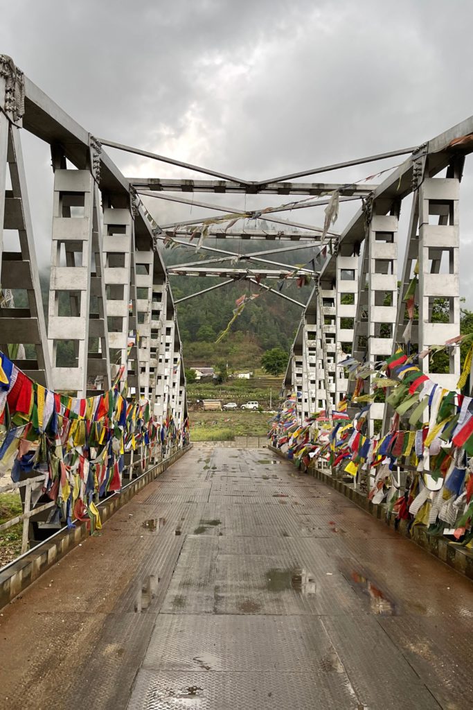 A metal bridge with prayer flags in Sangti Valley